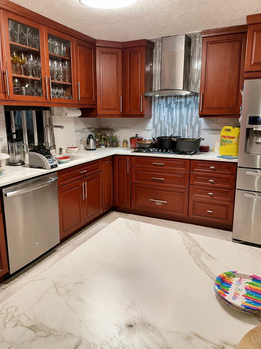 Before: cherry cabinets, white subway tile and a mosaic accent stripe