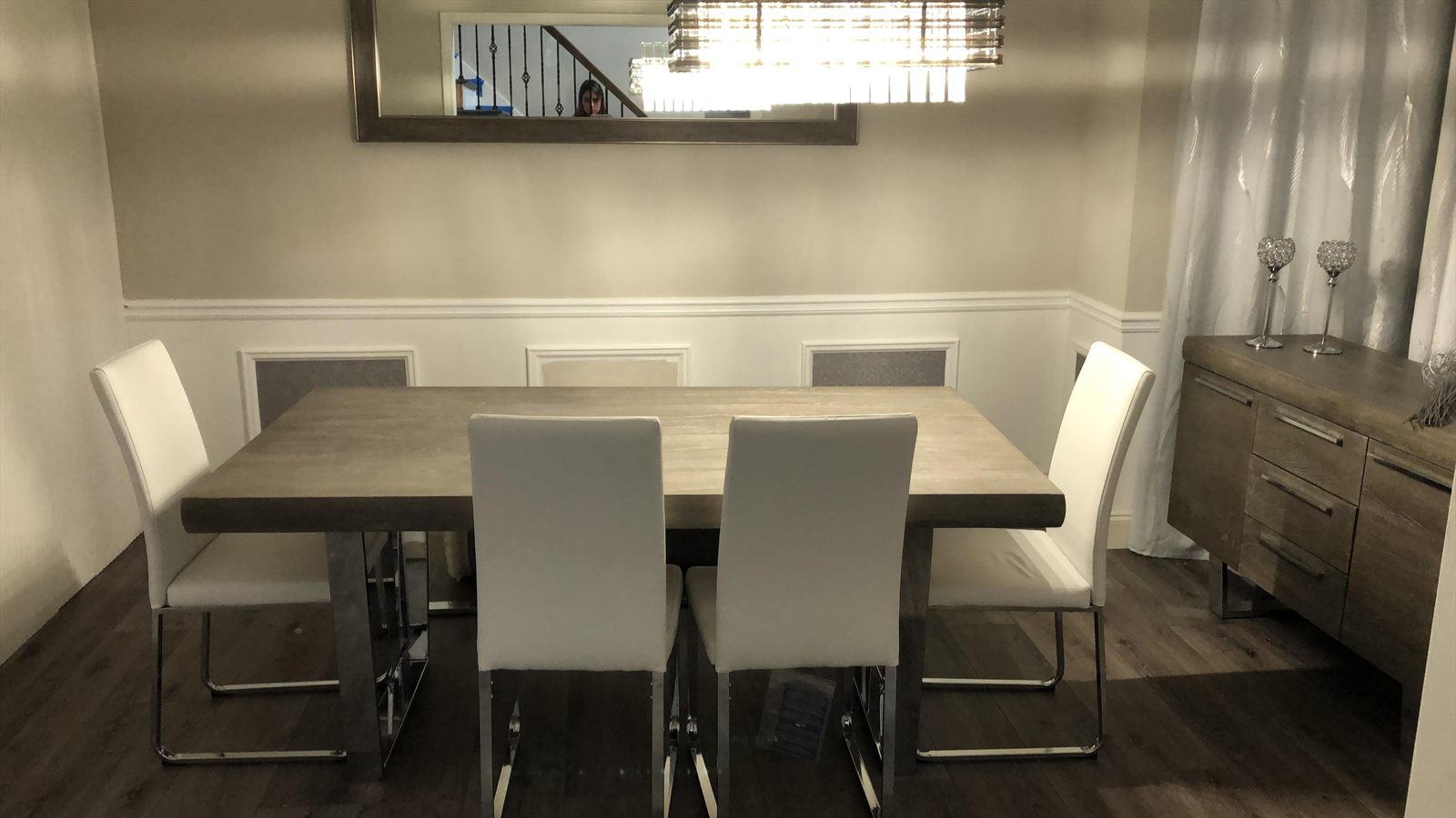 The same dining room before renovation, dated wall panels with grey inserts and a plain mirror